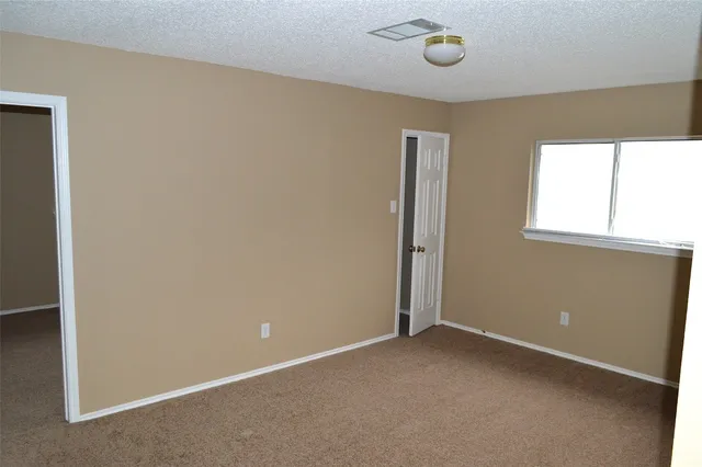 an empty room with windows and closet