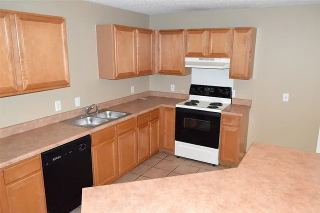 a kitchen with a stove sink and cabinets