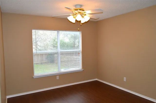 a view of a small space with wooden floor and a window