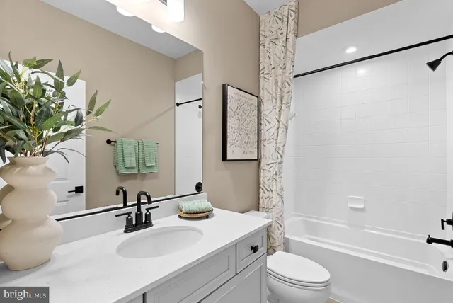 a bathroom with a sink a toilet a mirror a vanity and shower