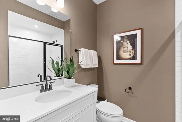 a bathroom with a sink mirror vanity and toilet