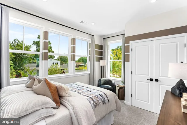 a bedroom with a large bed and a large window with balcony view