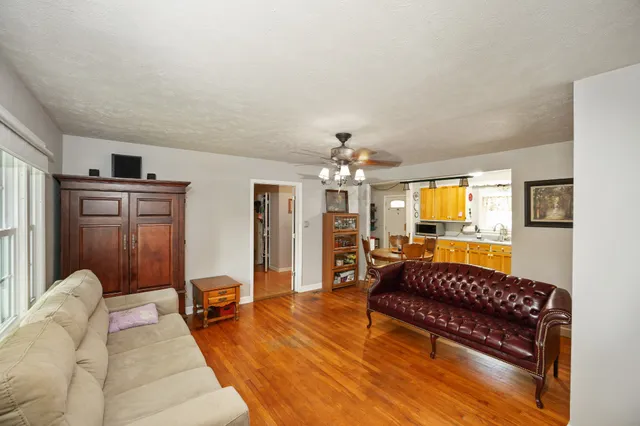 a living room with furniture flat screen tv and a large window