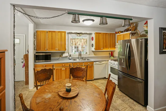 a kitchen with stainless steel appliances granite countertop a refrigerator a sink and a stove