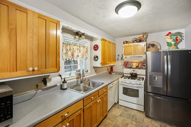 a kitchen with stainless steel appliances granite countertop a sink and a refrigerator