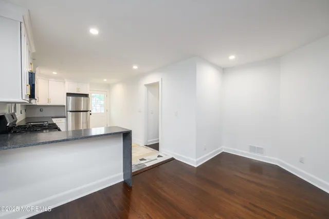 a view of kitchen with wooden floor and electronic appliances