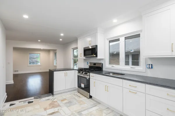 a kitchen with granite countertop a sink and stainless steel appliances