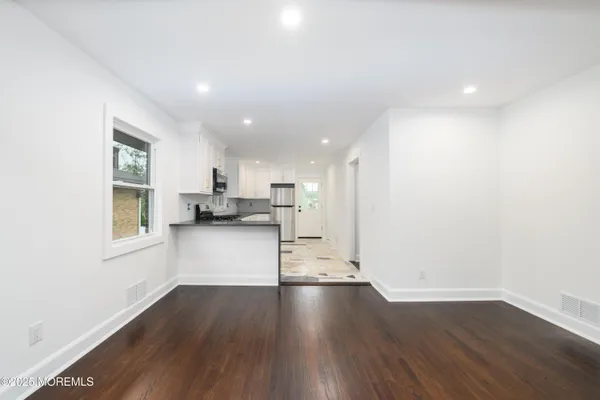 a kitchen with granite countertop a refrigerator stove top oven and sink