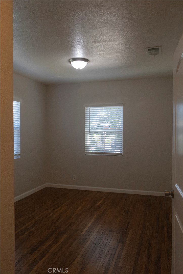 2412 Strong Avenue Commerce, CA 90040 - Photo 4 of 6 an empty room with wooden floor and windows