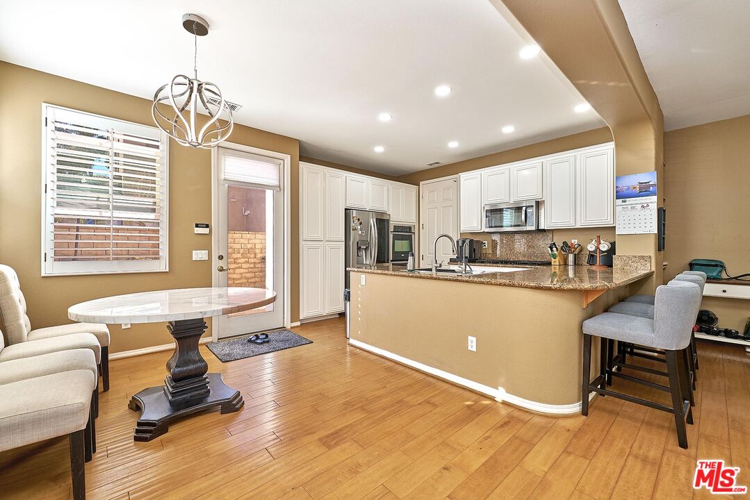 409 Spring Park Road Camarillo, CA 93012 - Photo 7 of 31 a living room with kitchen island furniture and a chandelier