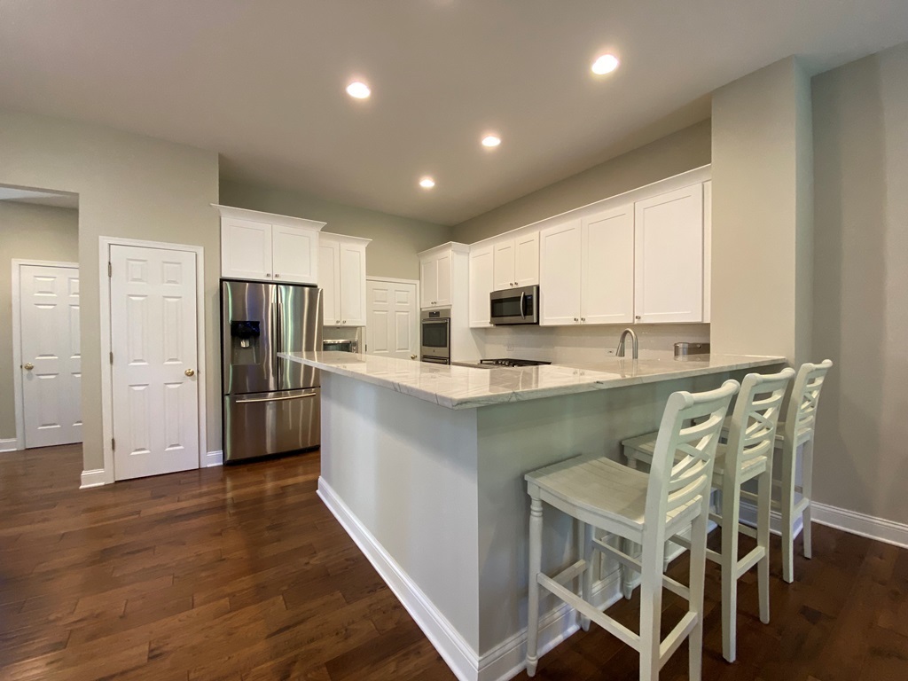 2428 Ridgewood Court Aurora, IL 60502 - Photo 10 of 40 a kitchen with stainless steel appliances kitchen island granite countertop a refrigerator a stove microwave and cabinets