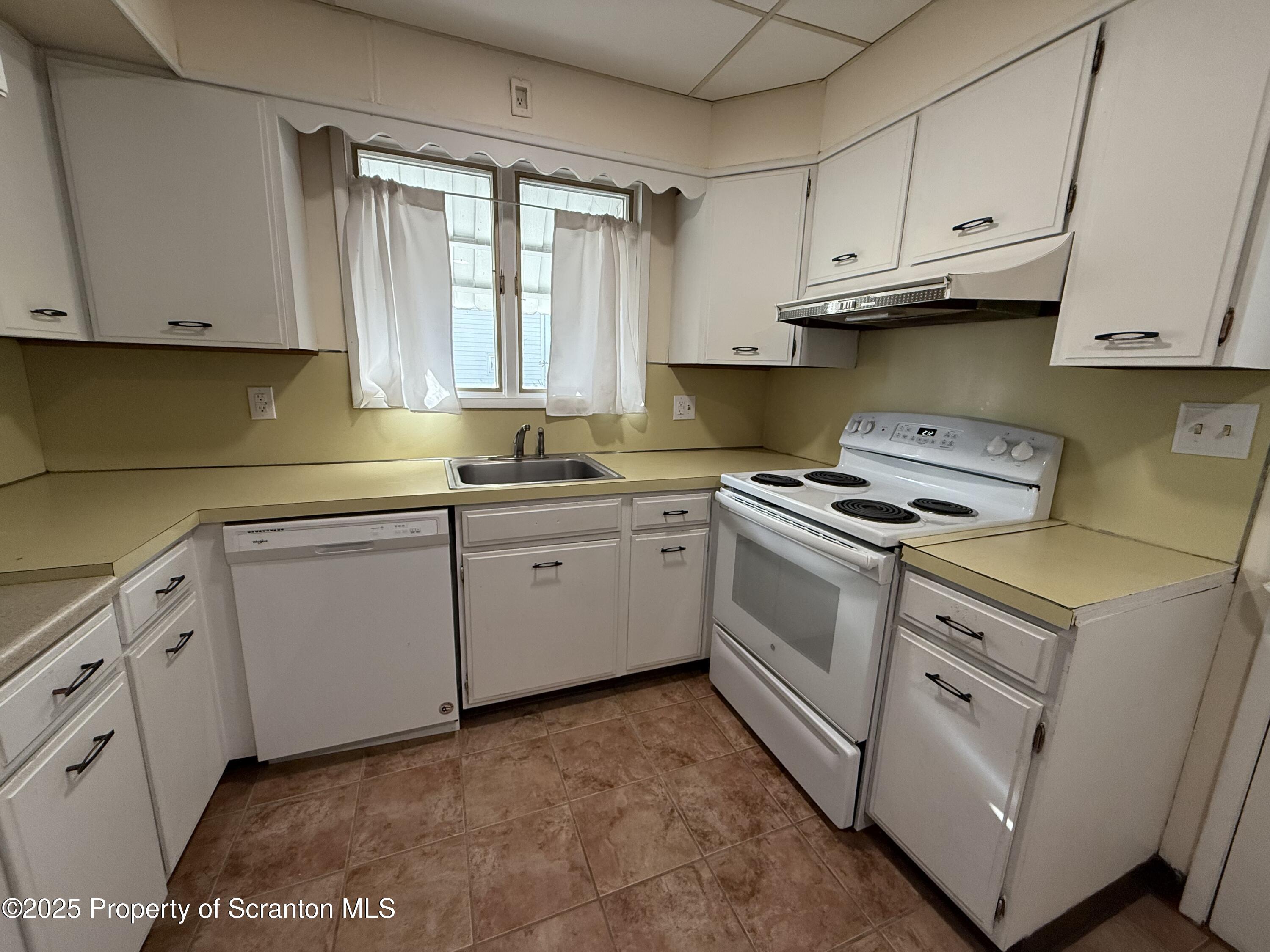 301 Monument Avenue Wyoming, PA 18644 - Photo 14 of 37 a kitchen with cabinets appliances a sink and a window