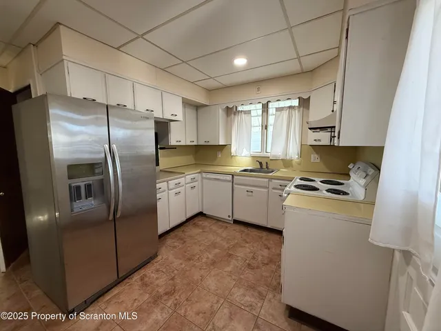 a kitchen with white cabinets and white appliances
