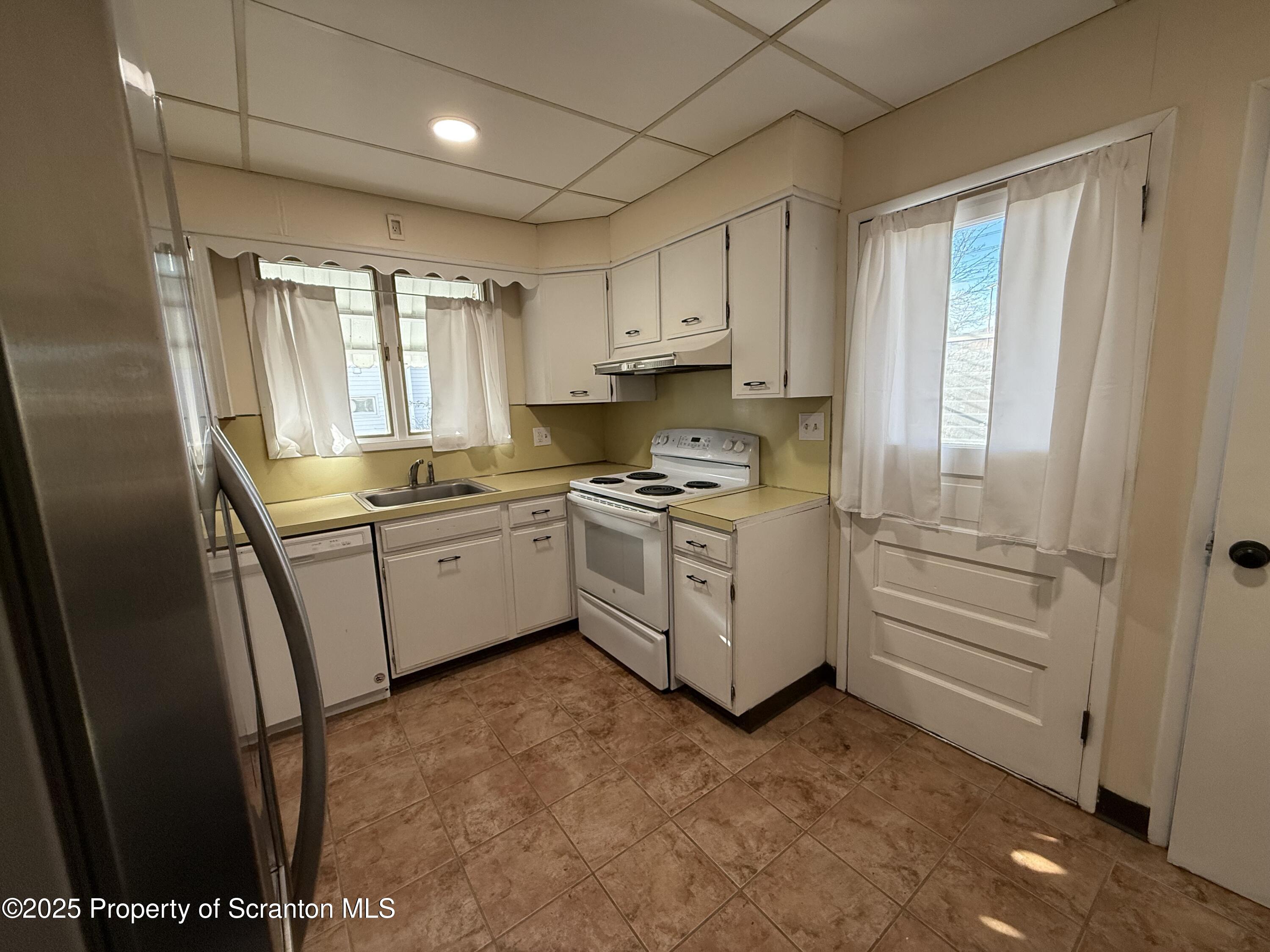 301 Monument Avenue Wyoming, PA 18644 - Photo 16 of 37 a kitchen with white cabinets and white appliances