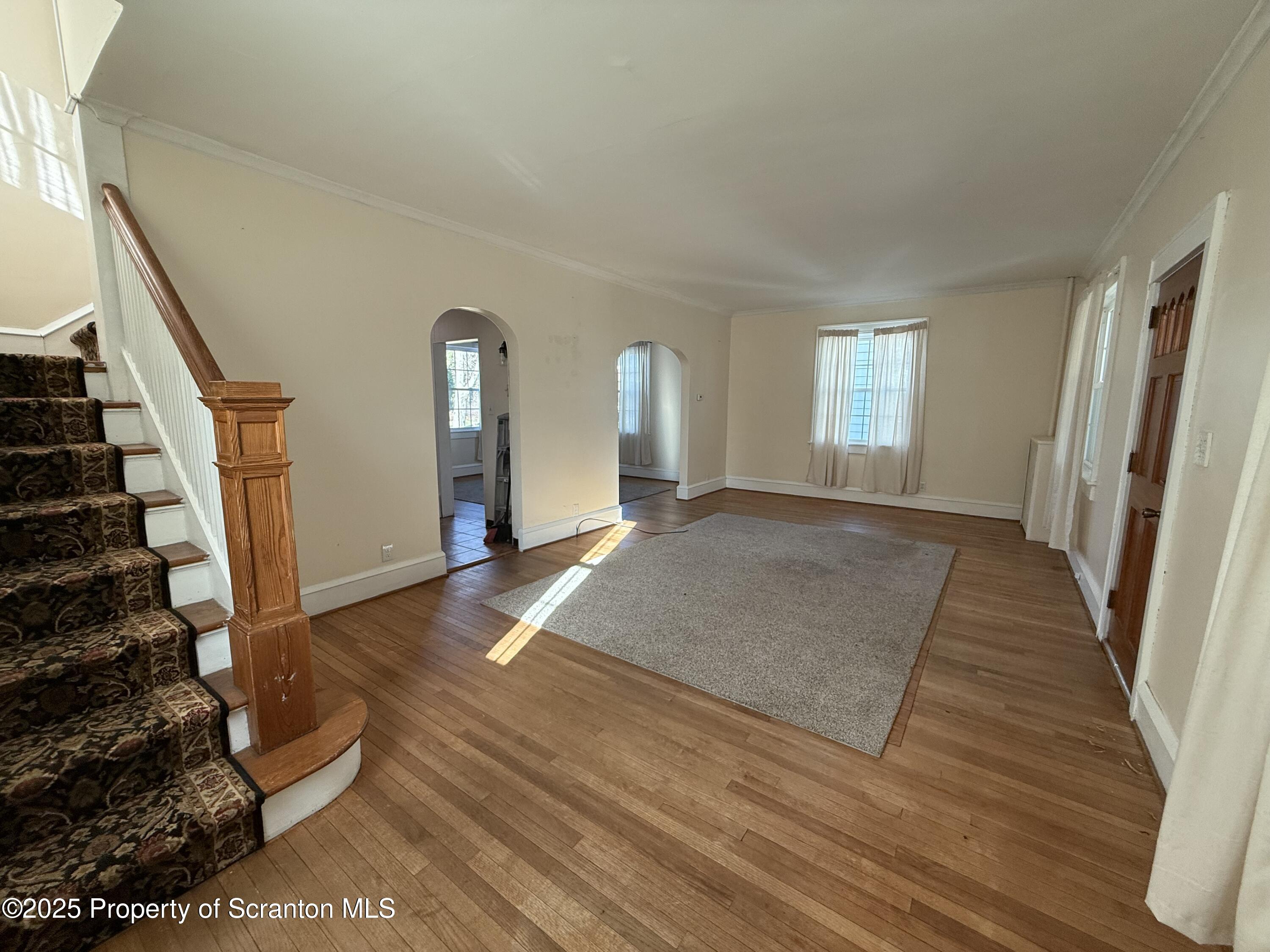 301 Monument Avenue Wyoming, PA 18644 - Photo 2 of 37 a view of a livingroom with wooden floor and stairs