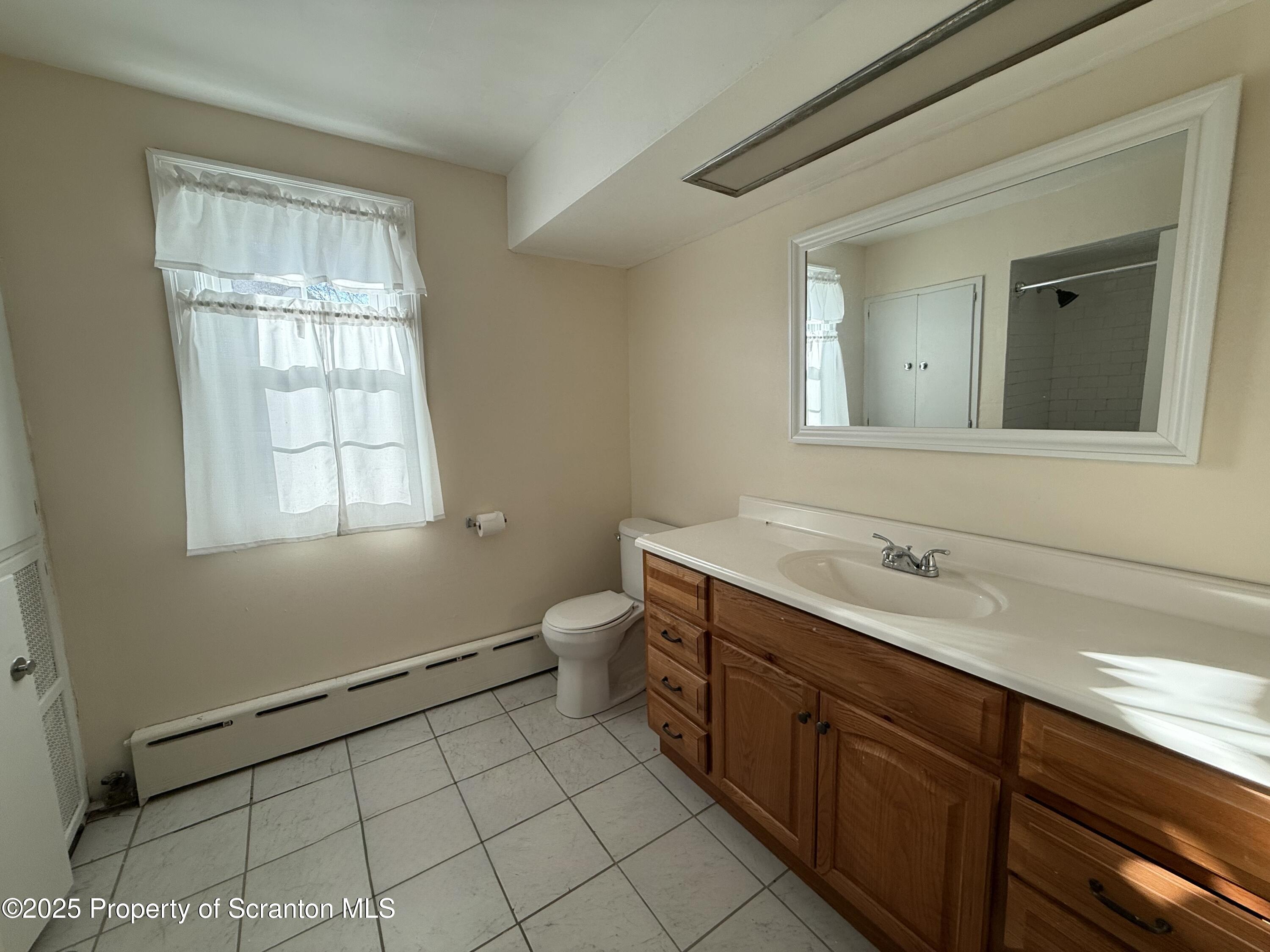 301 Monument Avenue Wyoming, PA 18644 - Photo 29 of 37 a spacious bathroom with a toilet sink and mirror