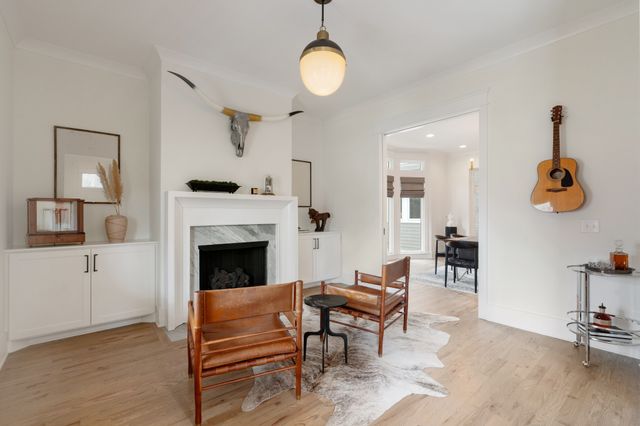 a living room with furniture kitchen view and a chandelier