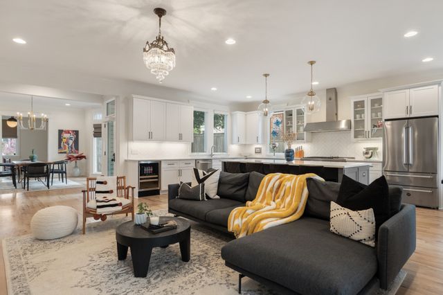 a kitchen with stainless steel appliances a dining table chairs sink and wooden floor