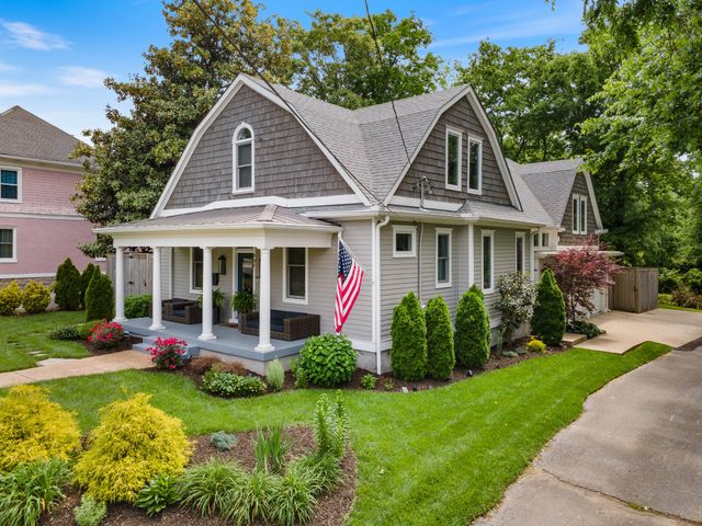 a view of a house with a yard and potted plants