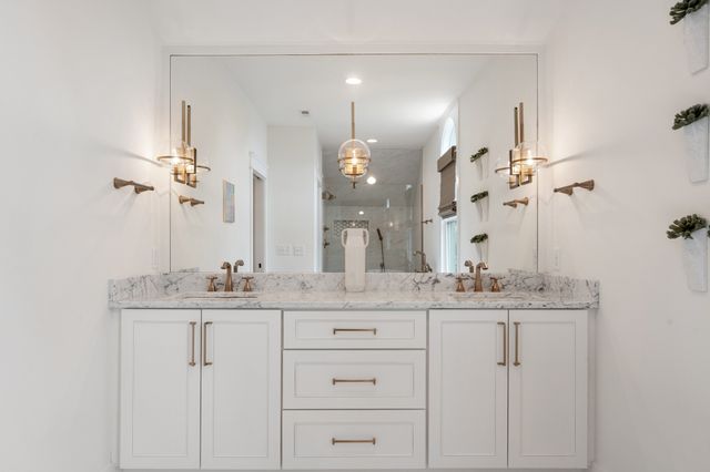 a bedroom with a bed and dresser with wooden floor