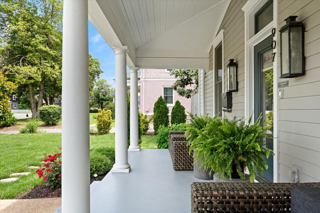 a view of a hallway with wooden floor windows and a living room
