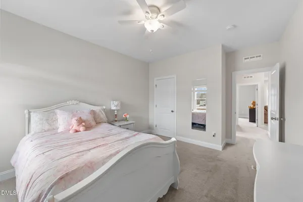 a bedroom with a bed and a chandelier fan