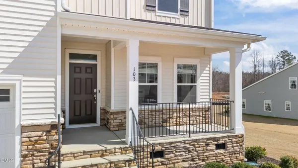 a view of a white house with swimming pool and sitting area