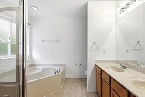a bathroom with a tub sink and mirror