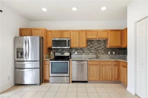 a kitchen with stainless steel appliances granite countertop a refrigerator and a stove top oven