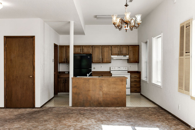 299 West Center Street, Unit 2 Logan, UT 84321 - Photo 10 of 46 Kitchen area featuring wood-finish cabinetry, a white range, and a black refrigerator