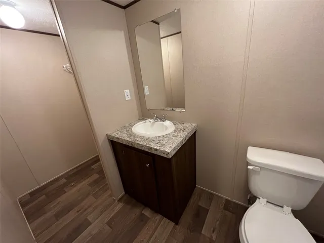 a bathroom with a granite countertop sink and a toilet