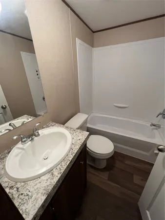 a bathroom with a granite countertop sink toilet and a mirror