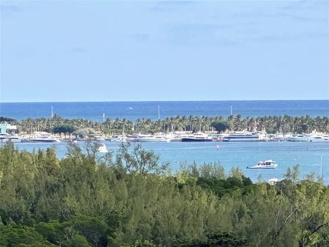 an aerial view of ocean and residential houses with outdoor space