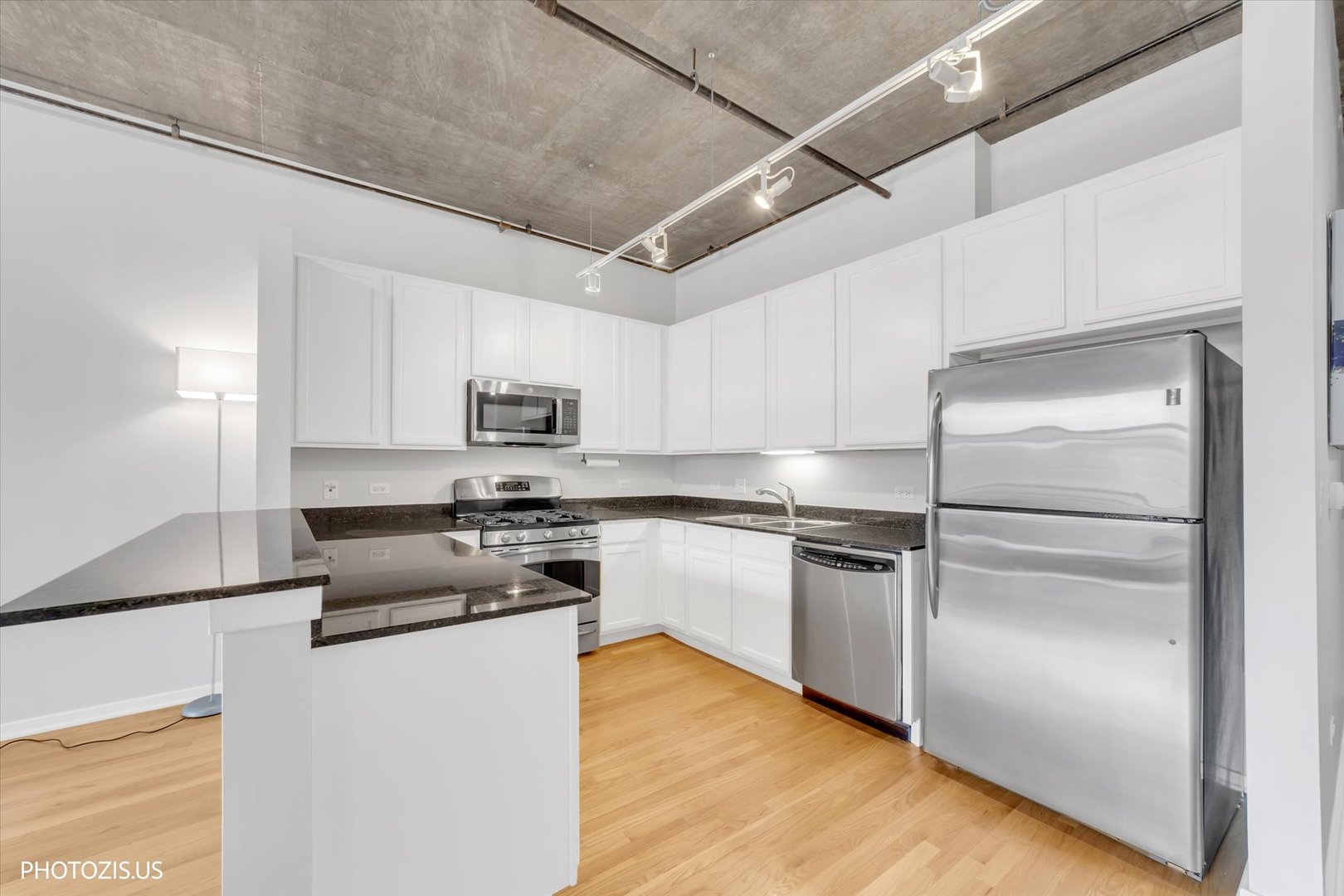 520 South State Street, Unit 712 Chicago, IL 60605 - Photo 11 of 28 a kitchen with kitchen island a counter top space a sink and stainless steel appliances