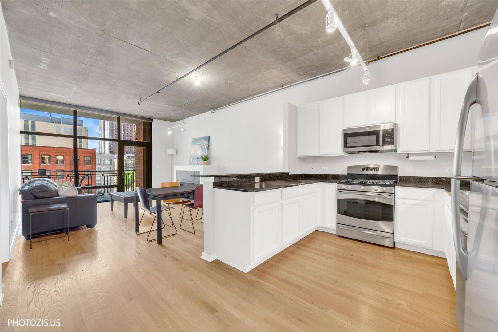 520 South State Street, Unit 712 Chicago, IL 60605 - Photo 10 of 28 a kitchen with granite countertop a stove top oven a sink a dining table and chairs