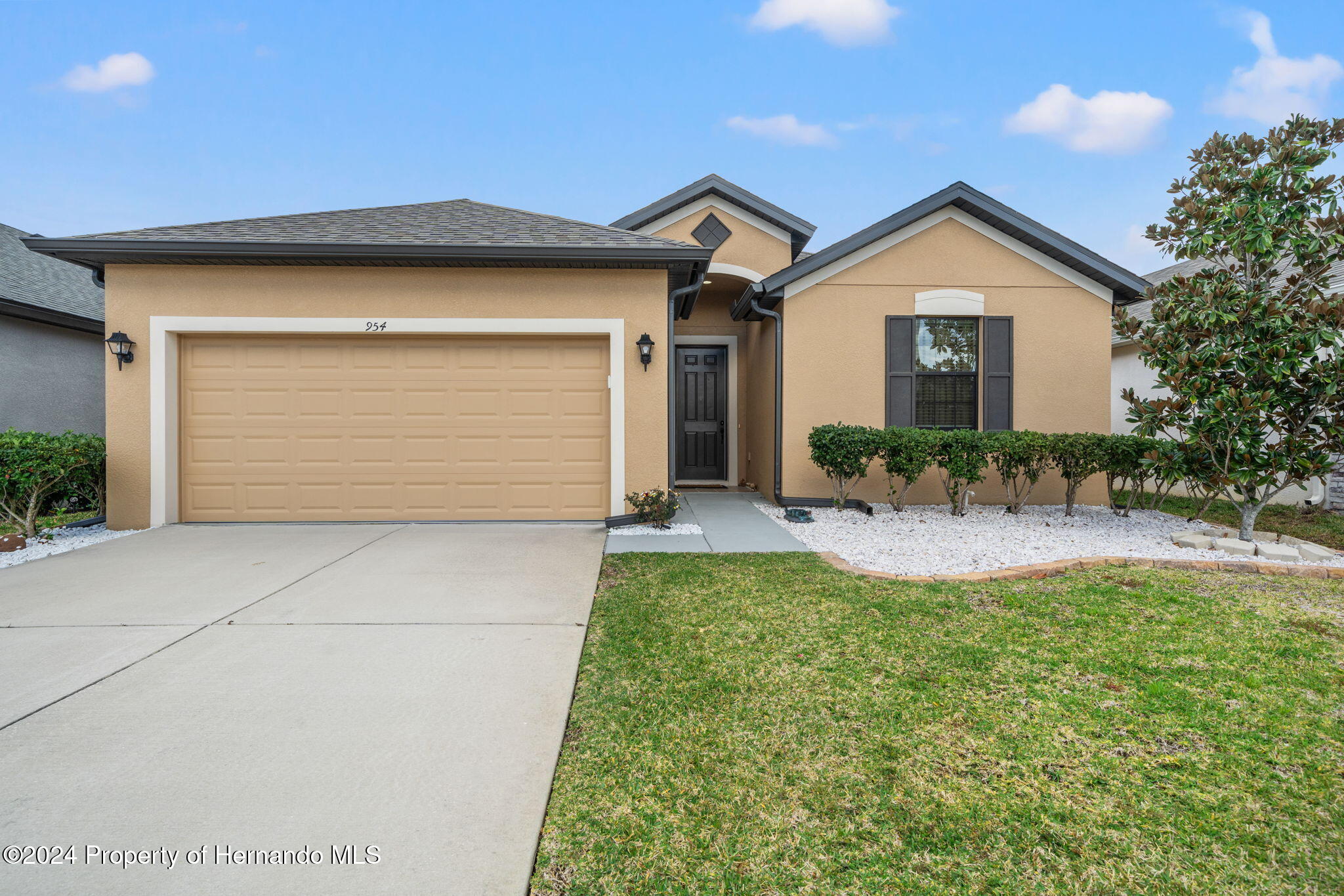 a front view of a house with a yard and garage