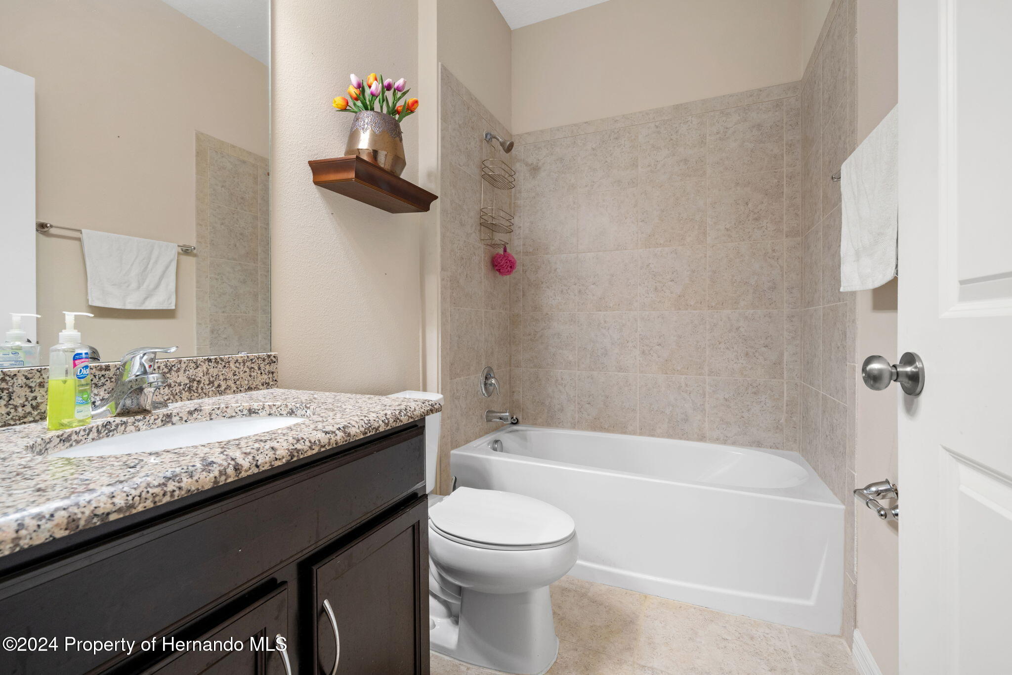 954 Old Windsor Way Spring Hill, FL 34609 - Photo 16 of 32 a bathroom with a granite countertop sink a toilet and bathtub