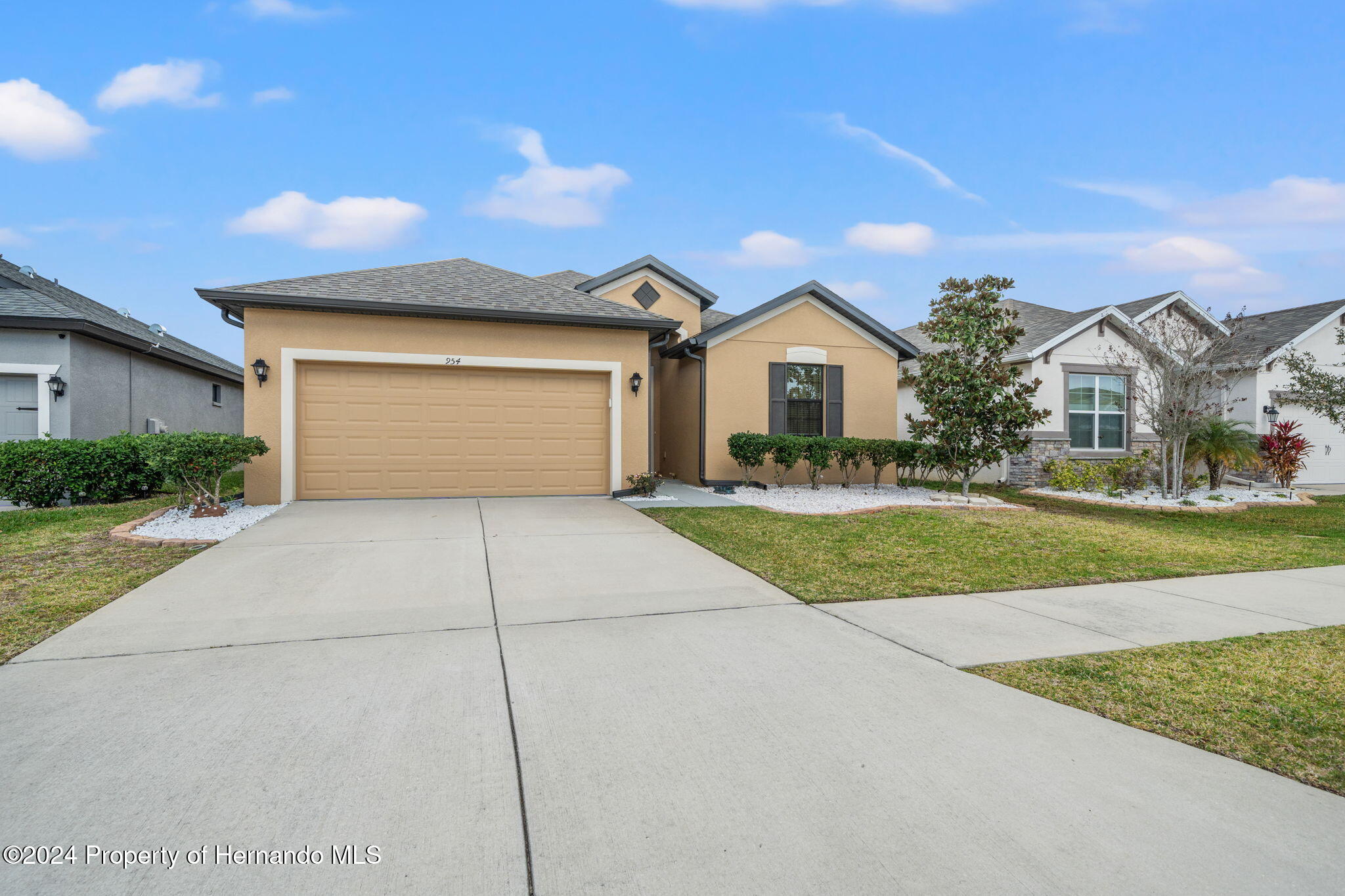954 Old Windsor Way Spring Hill, FL 34609 - Photo 2 of 32 a front view of a house with a yard and garage