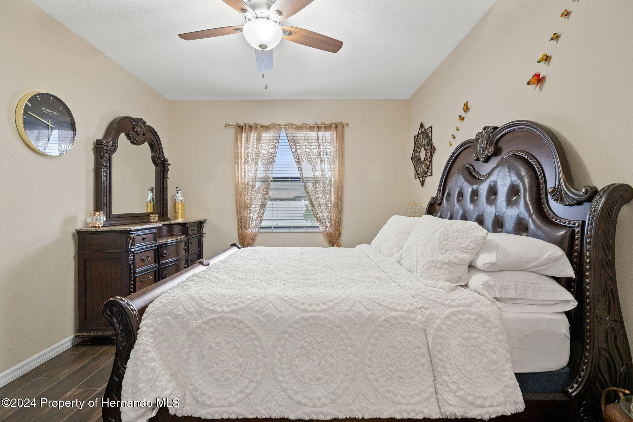 954 Old Windsor Way Spring Hill, FL 34609 - Photo 21 of 32 a bedroom with a bed and a chandelier