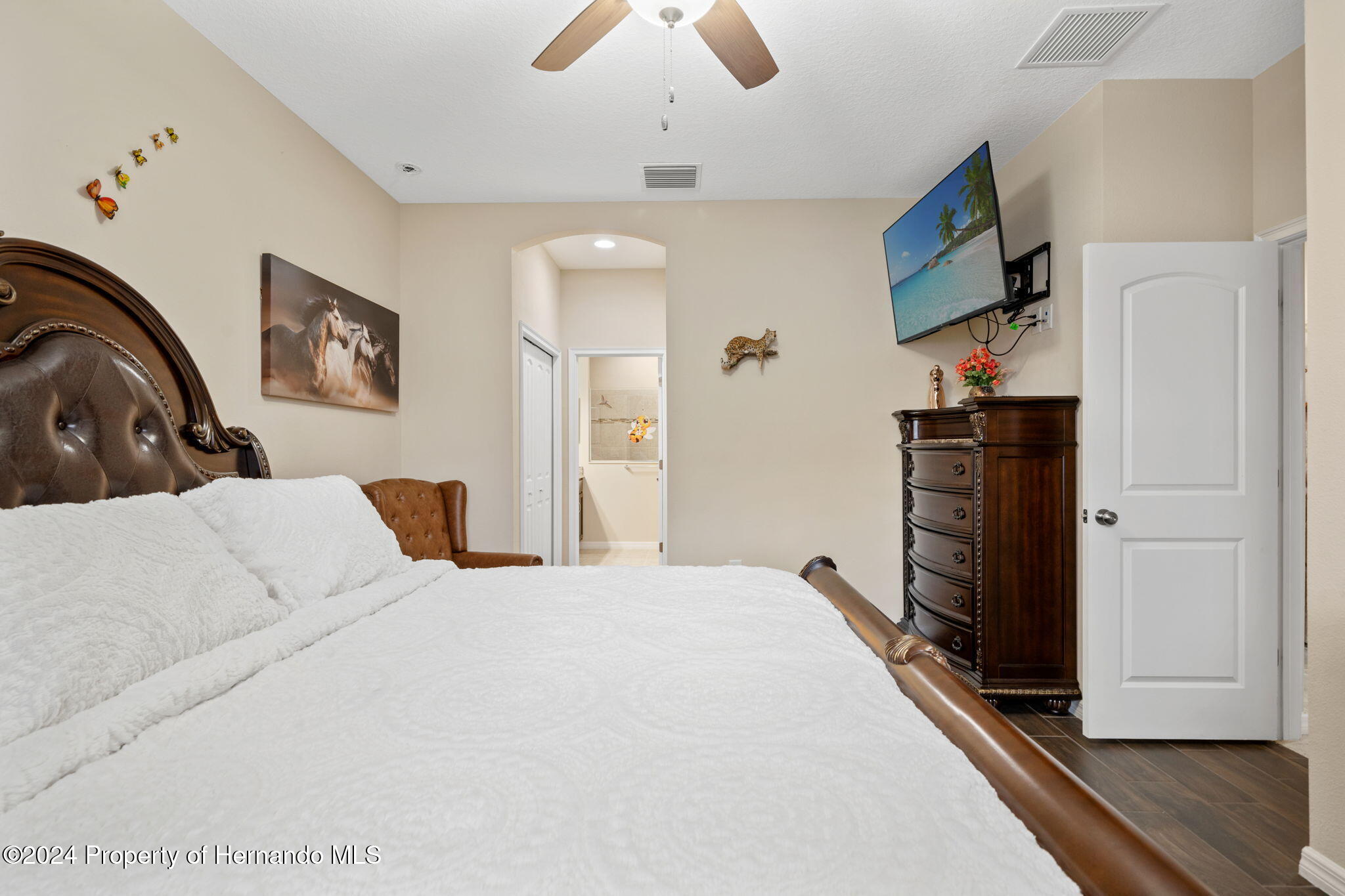 954 Old Windsor Way Spring Hill, FL 34609 - Photo 22 of 32 a bedroom with a bed and a chandelier