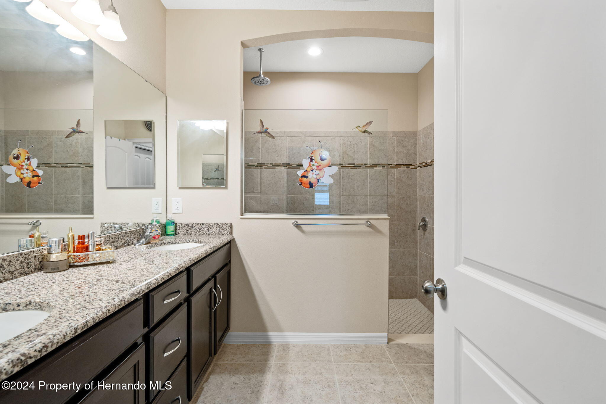 954 Old Windsor Way Spring Hill, FL 34609 - Photo 24 of 32 a bathroom with a granite countertop sink a mirror and a shower