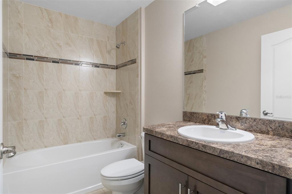 10342 Mirage Avenue Weeki Wachee, FL 34614 - Photo 41 of 45 a bathroom with a granite countertop sink toilet and shower