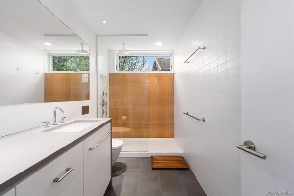 a bathroom with a sink a large mirror and shower