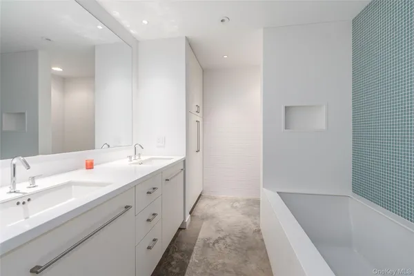 a bathroom with a tub sink and mirror