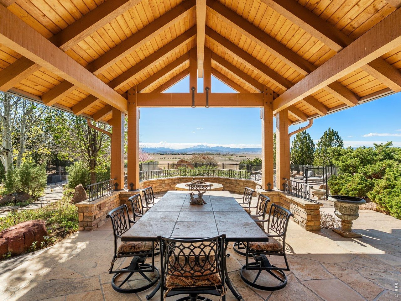 15383 East County Line Road Berthoud, CO 80513 - Photo 24 of 47 a view of a patio with table and chairs and couches with wooden floor and fence