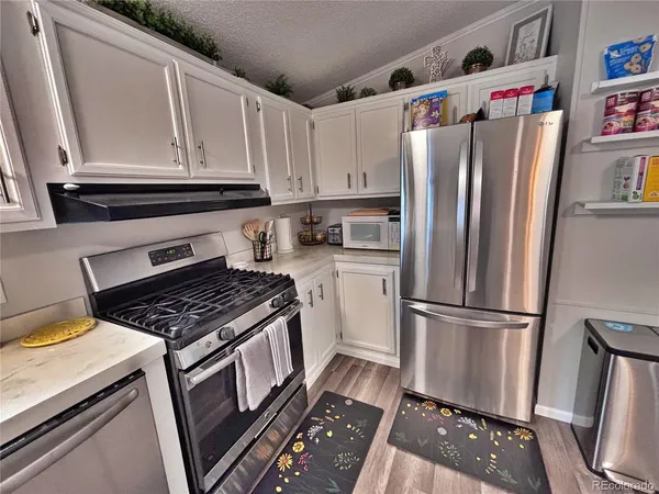 a kitchen with stainless steel appliances a refrigerator and a cabinets