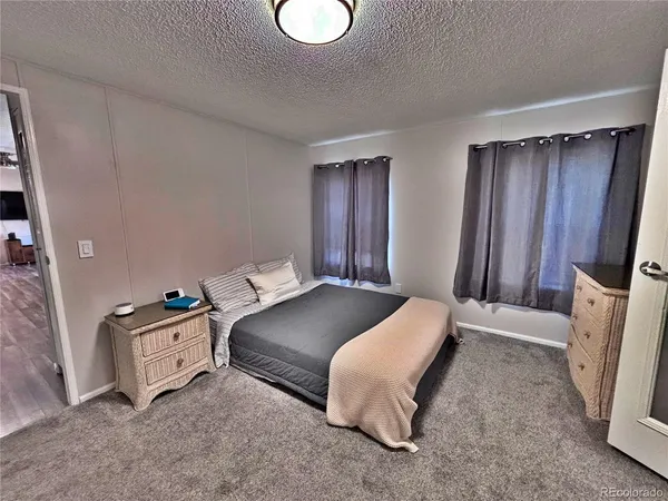 a spacious bedroom with a bed and a dresser