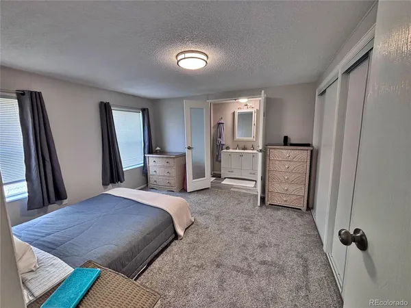 a spacious bedroom with a bed and a dresser