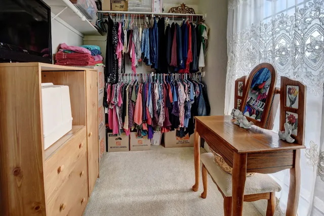 a bedroom with a bed closet and flat tv screen