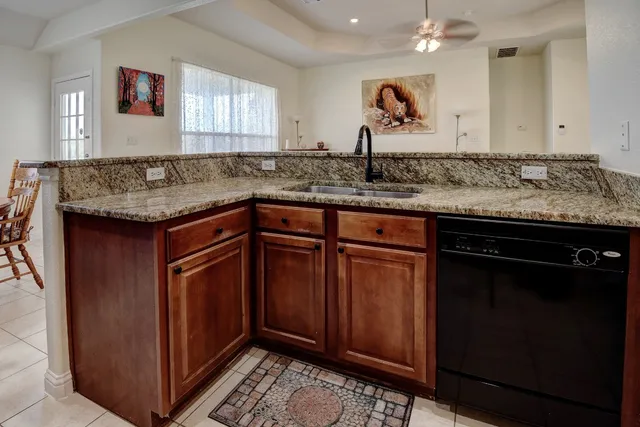 a kitchen with granite countertop a sink and cabinets